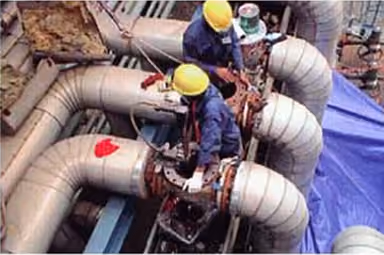 KEI technicians working on valves in insulated pipework at a customer site