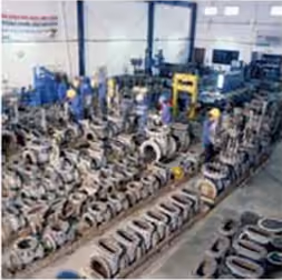 Valves laid out in rows on the floor of the KEI workshop during overhaul